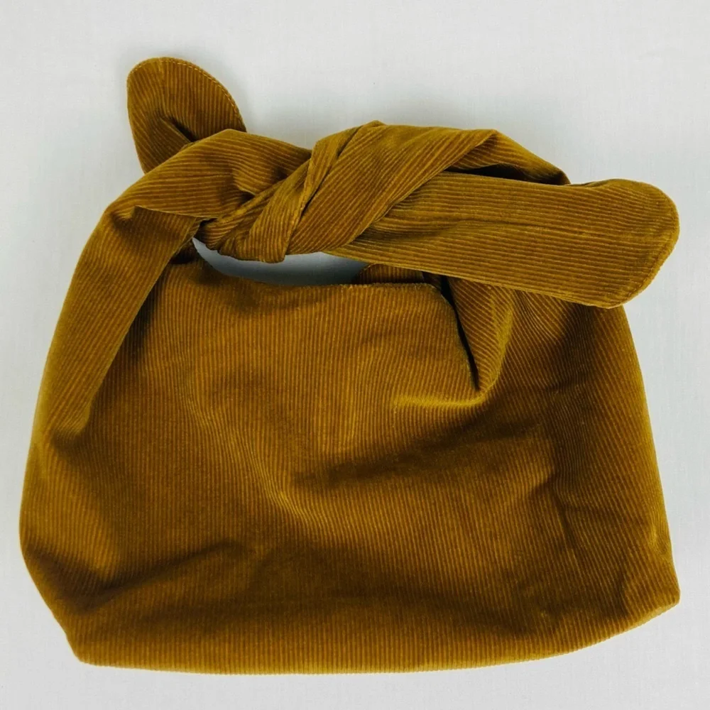Merit brown corduroy signature tie top make up bag.